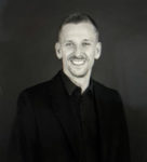 male black shirt dark background mustache